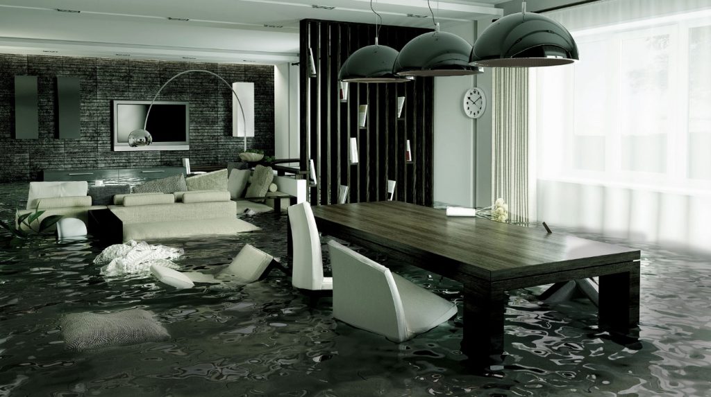 A modern living room and dining area is flooded, with water covering the floor, furniture partially submerged, and floating debris scattered throughout the space. An emergency plumber in Atlanta is needed to address what appears to be a burst pipe.