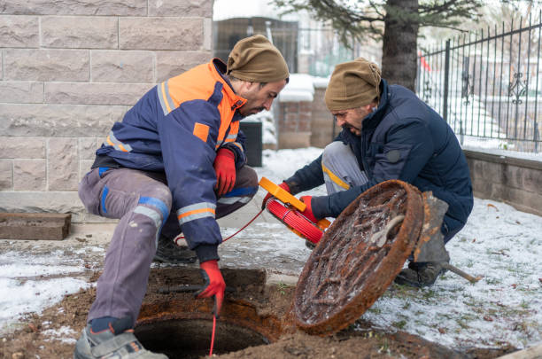 Plumbers Checking Sewer Manhole